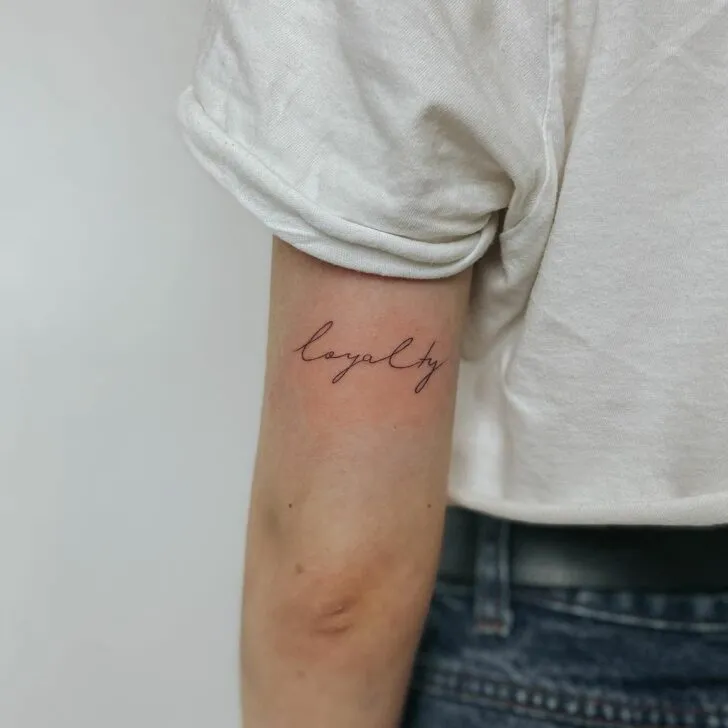 “loyalty” tattoo on the back of the elbow