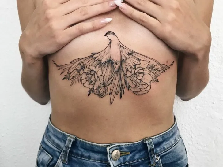 middle chest tattoo of a bird with flowers